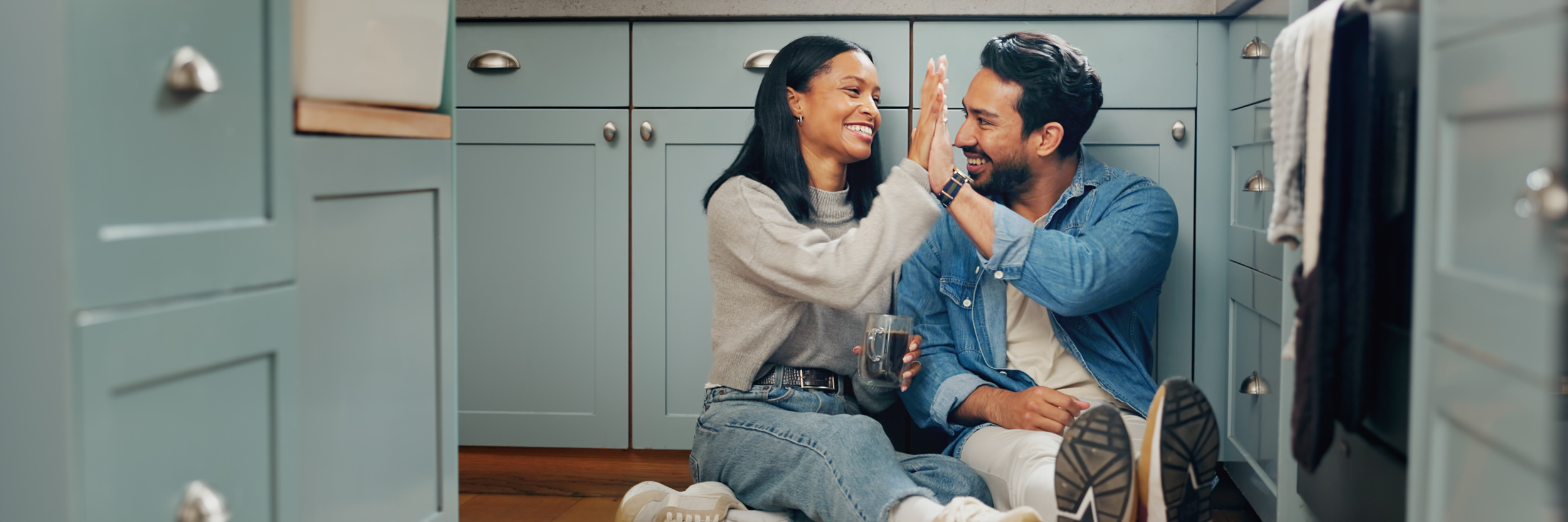 Couple high-fiving on kitchen floor