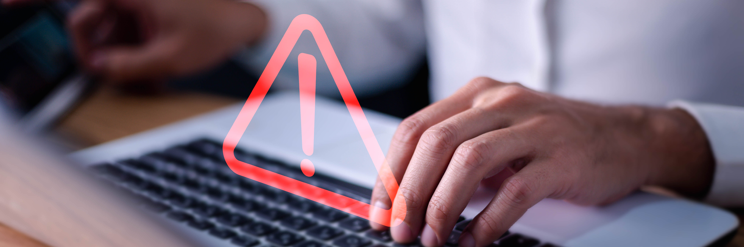 Hand on keyboard with warning sign