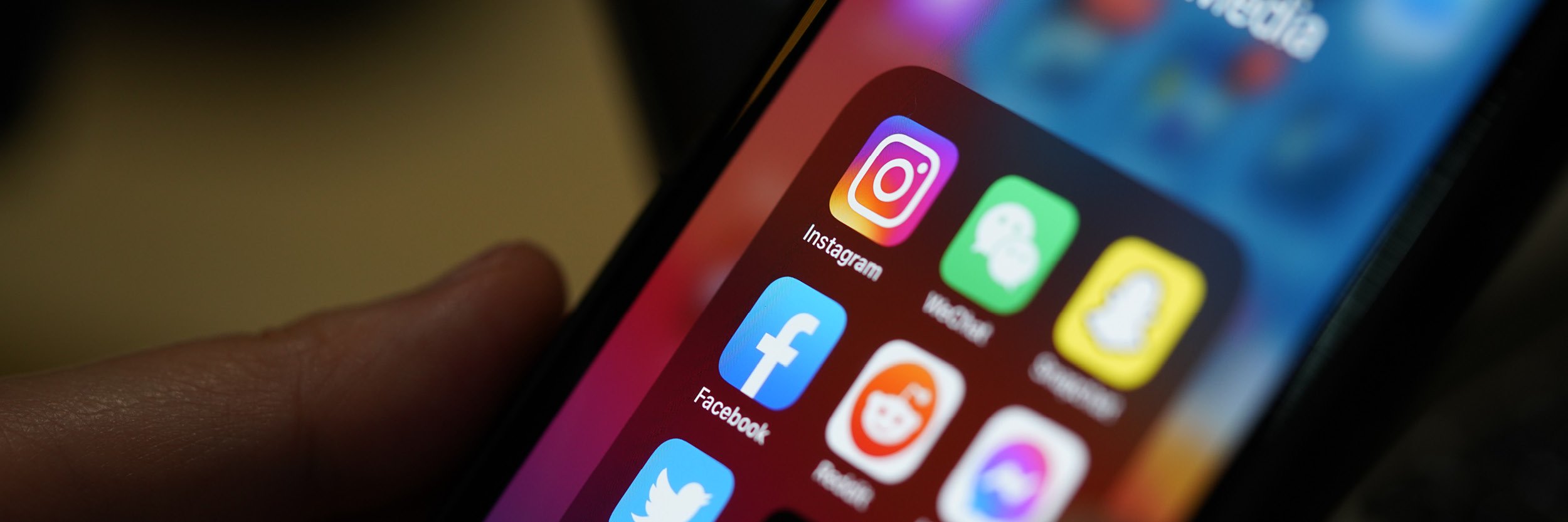 A photo of a phone showing social media apps