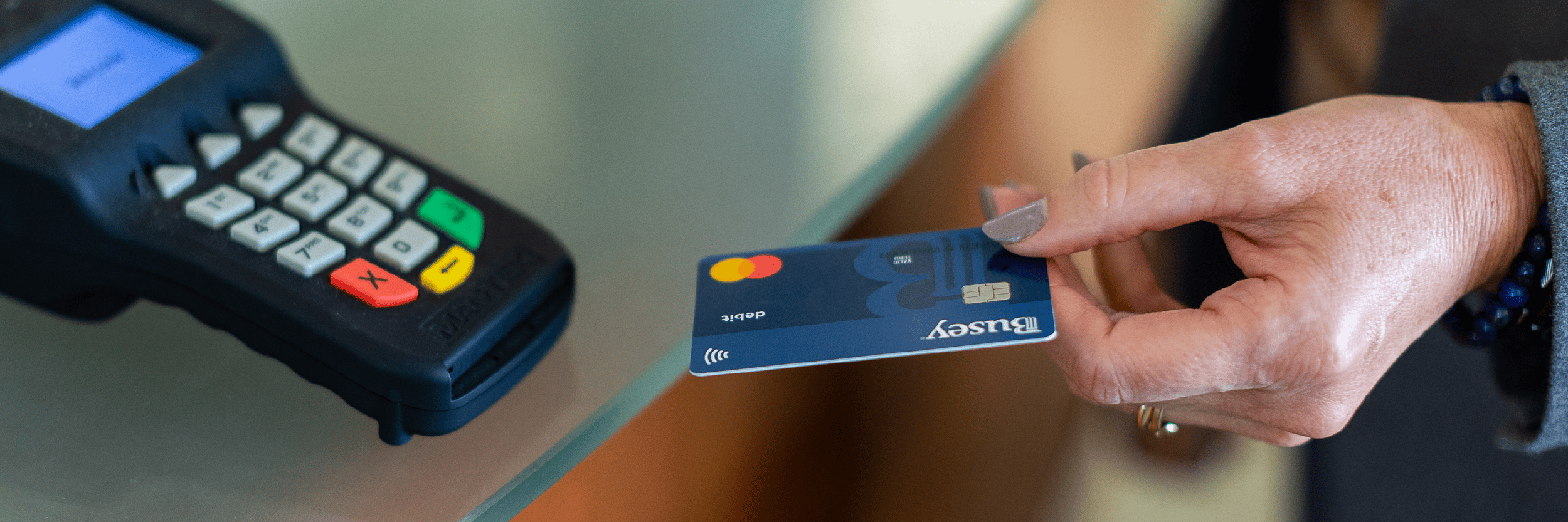 A person holding a credit card is ready to insert into a scanner
