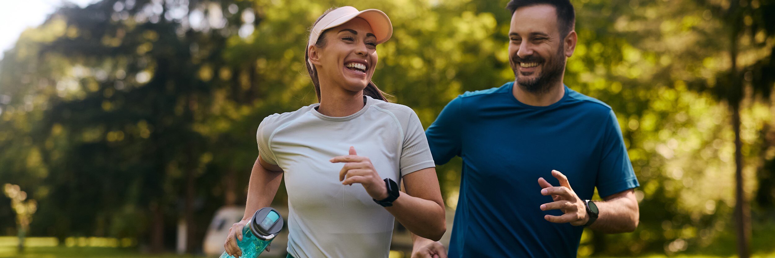 A man and woman smile as they jog.