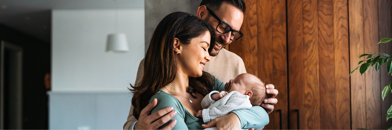 A man and woman stand with a baby.