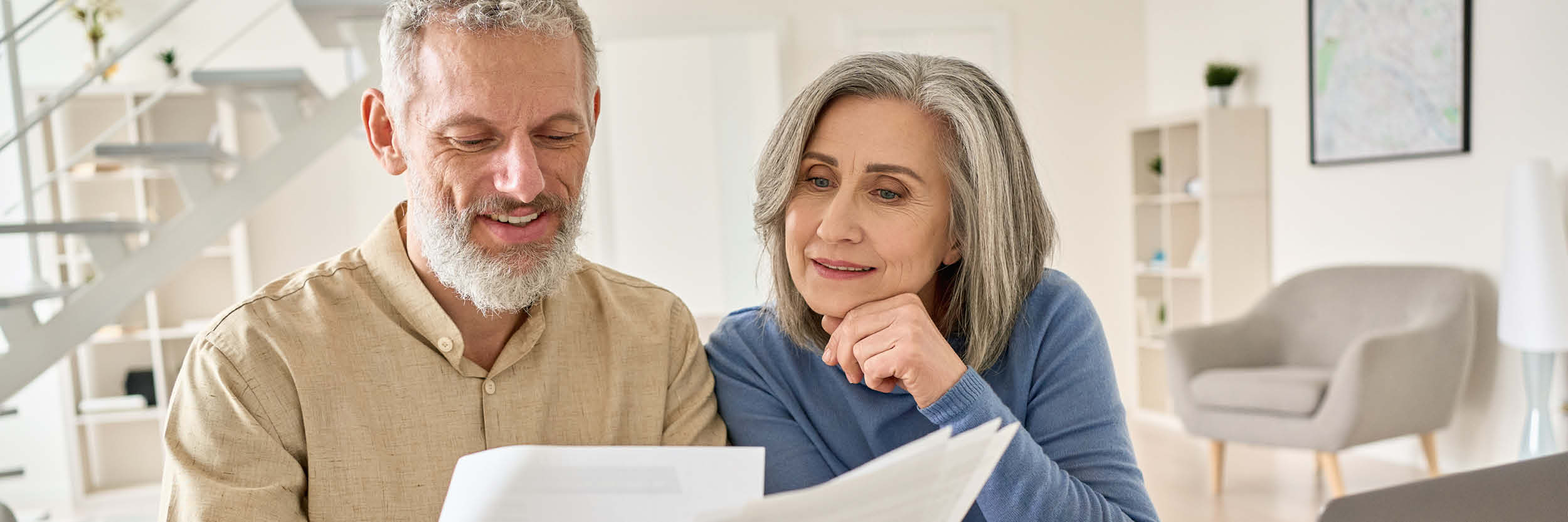 A man and a woman sit at a table looking at a piece of paper.