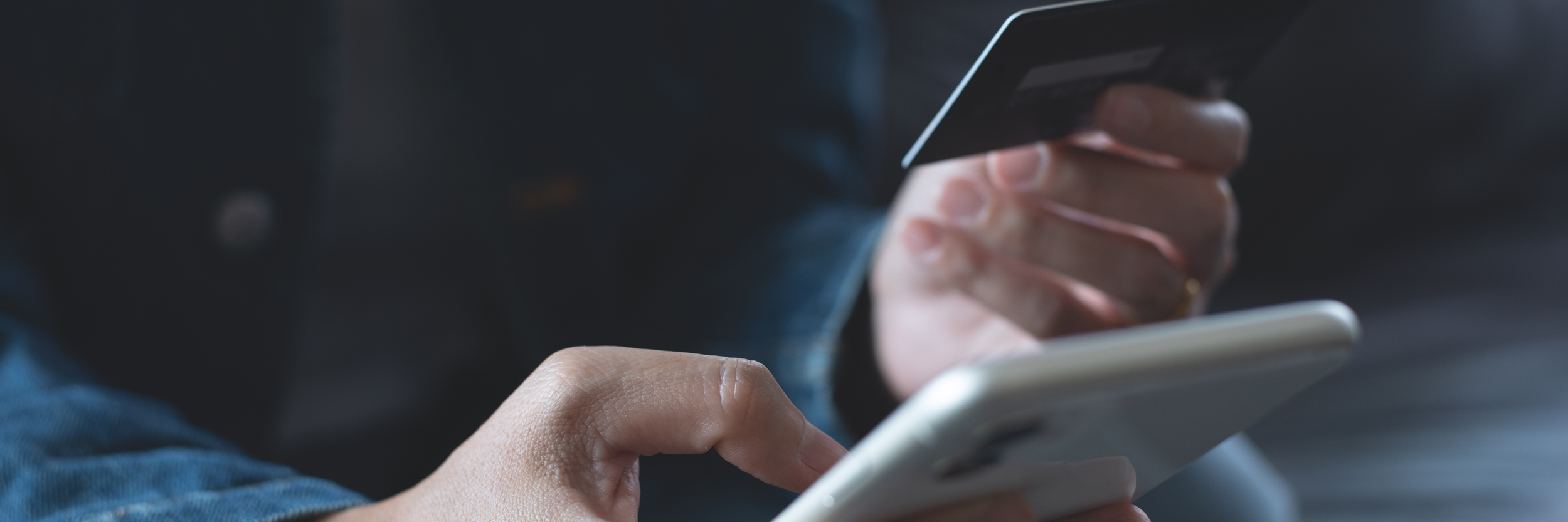 A person holding a credit card is entering information on their phone.