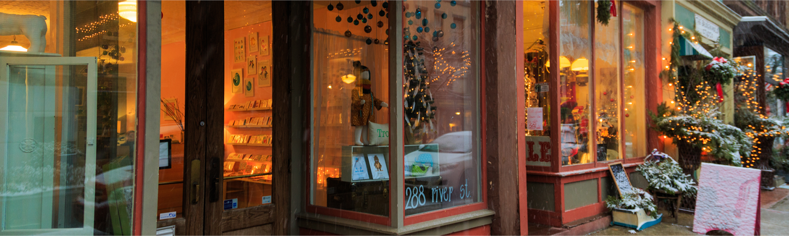 A photo of shops on a downtown street decorated for the holidays.