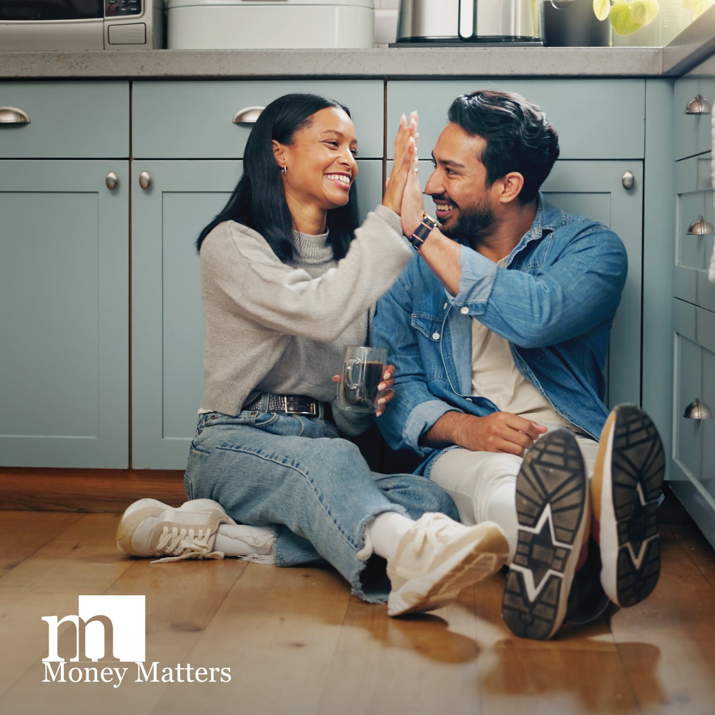 Couple high-fiving on kitchen floor