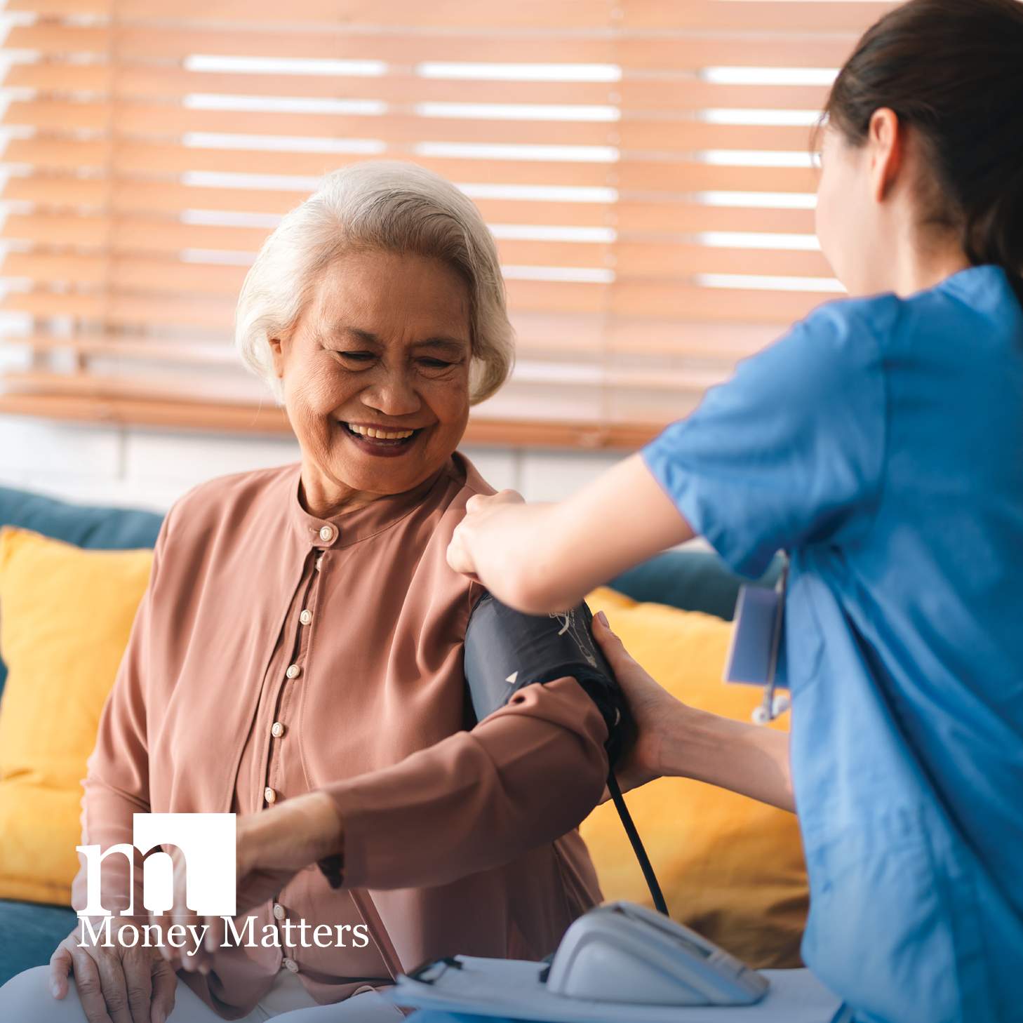 An older woman smiles as a nurse takes her blood pressure.
