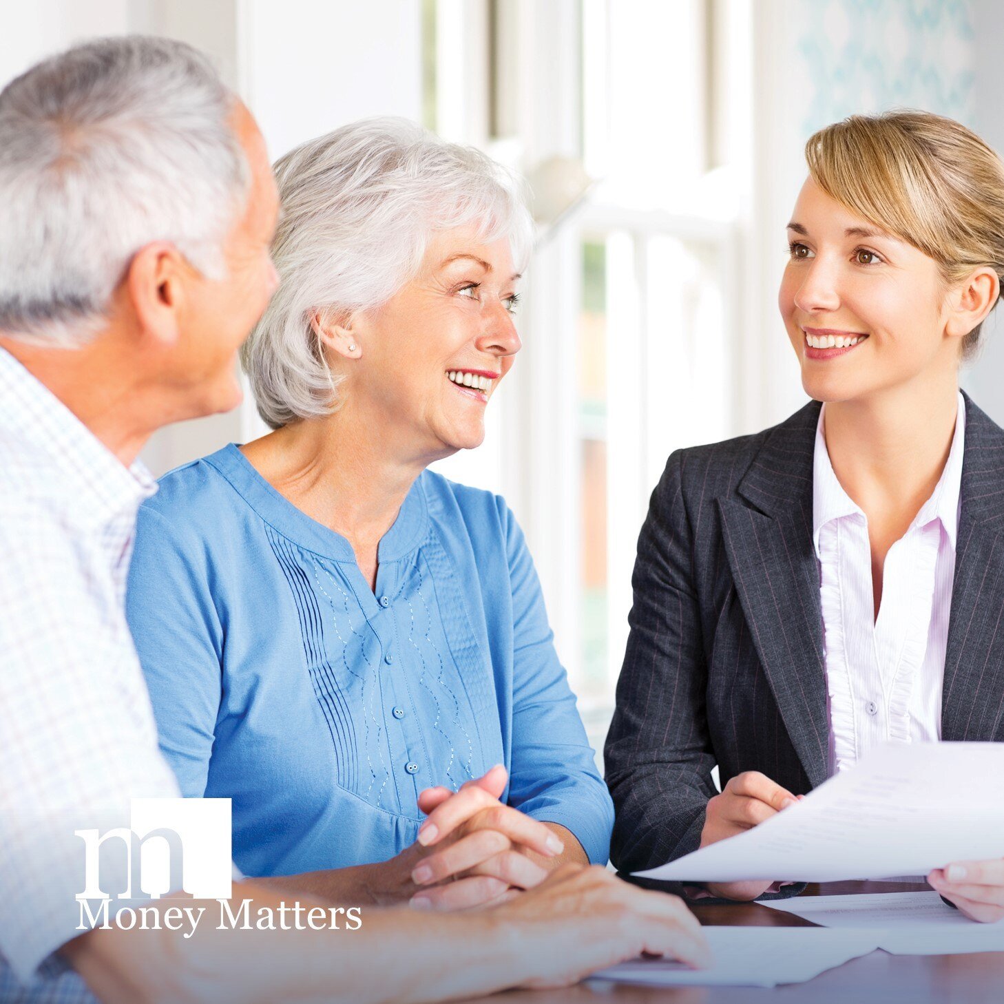 An older man and woman talk to a younger woman.