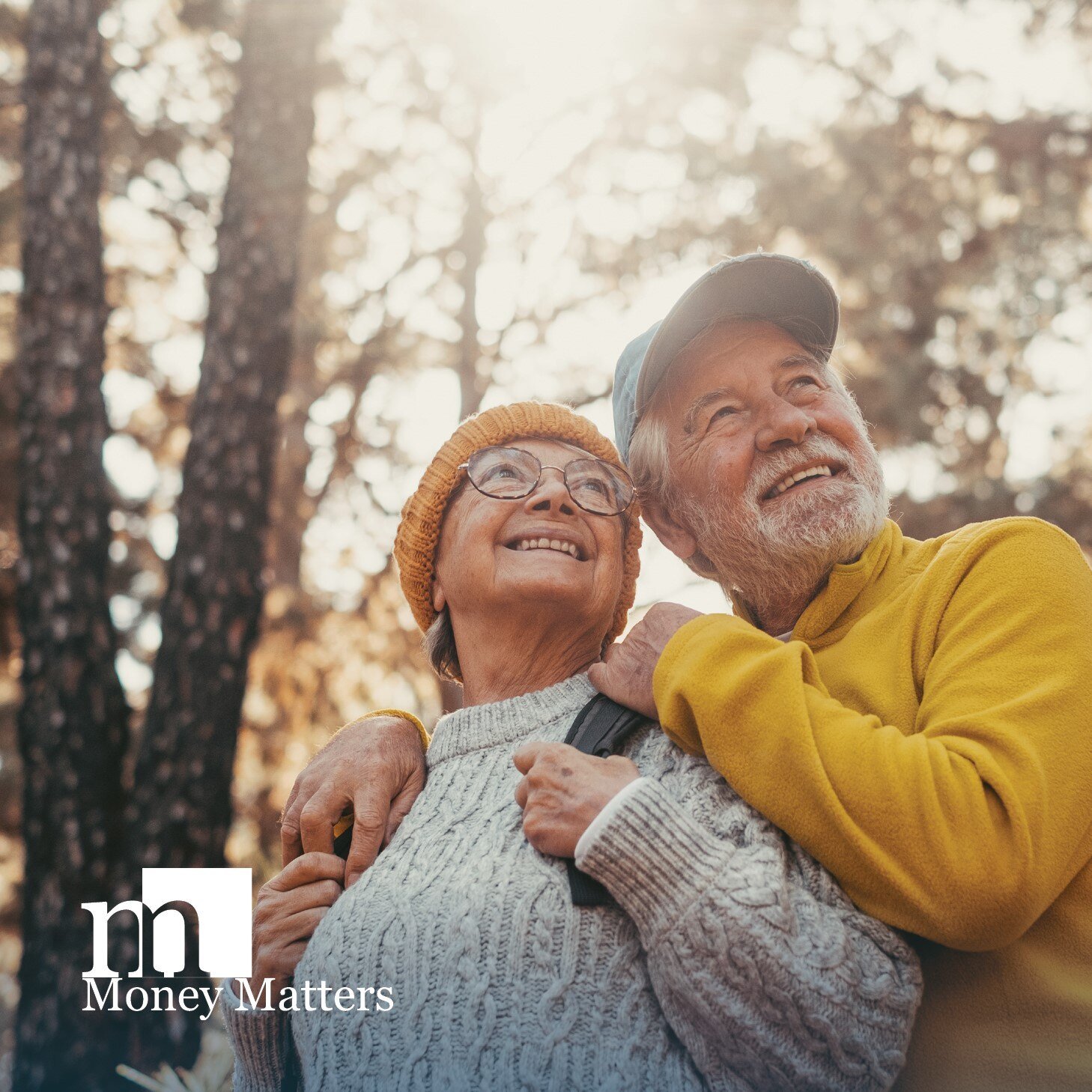 An older man and woman hike in the woods.