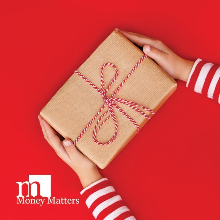 A woman hands are seen holding a gift-wrapped package.