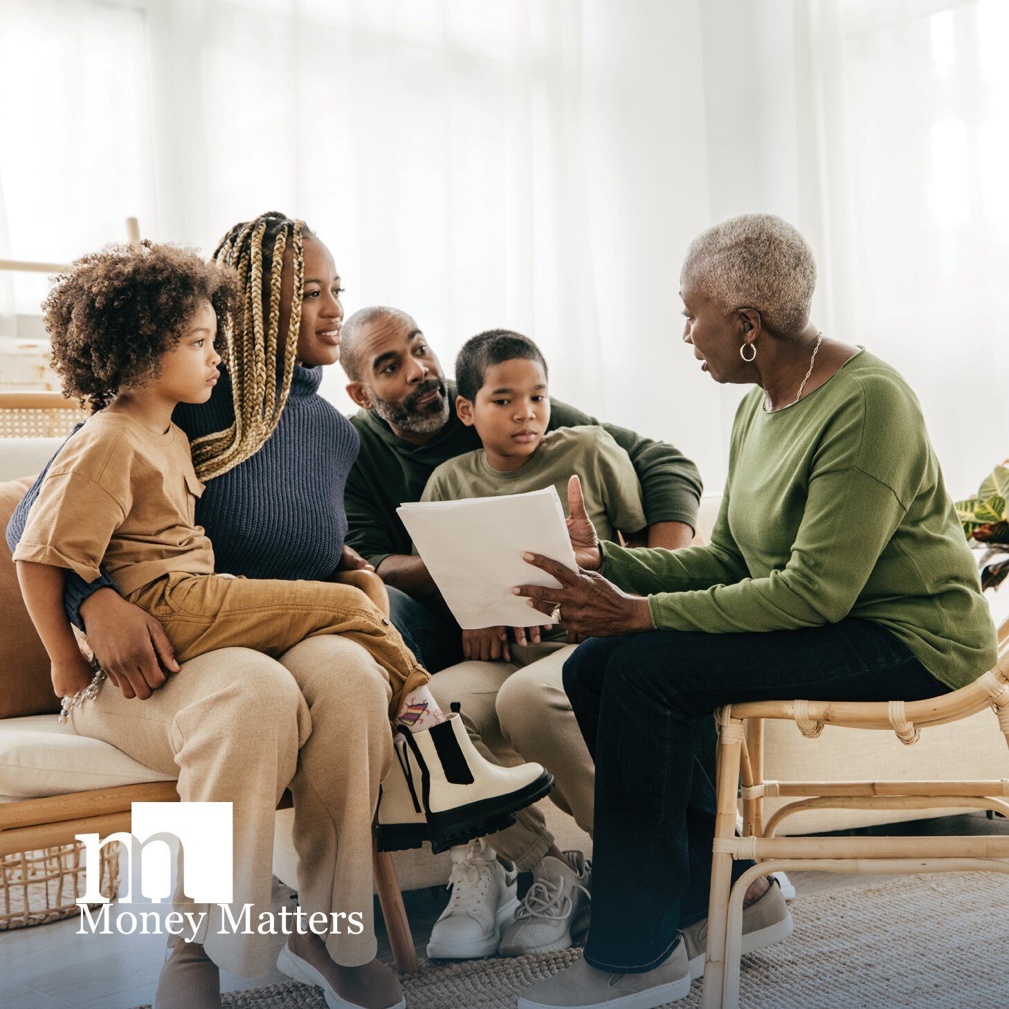 An older woman holds paperwork while sitting down with a younger woman and man and two boys.