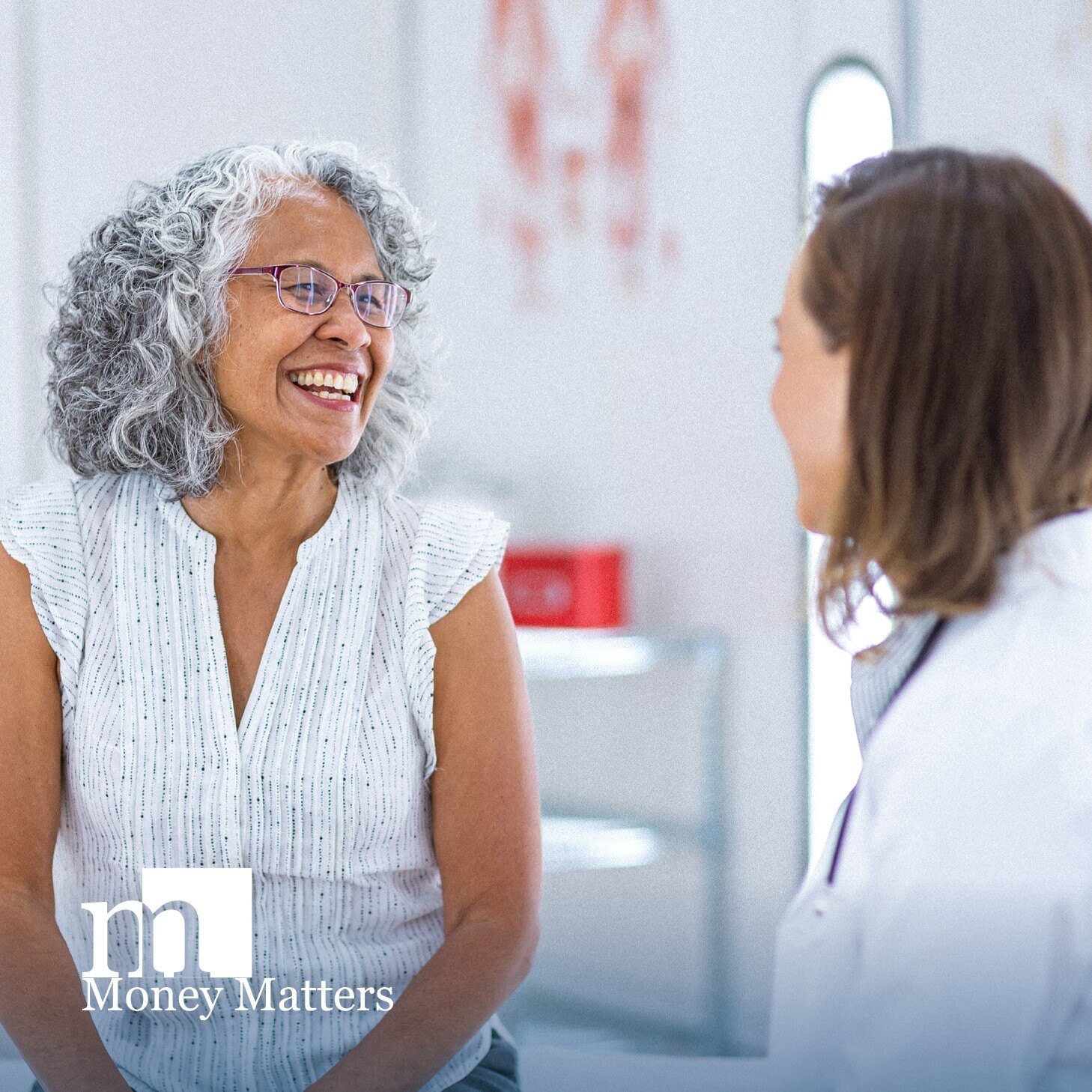 A woman smiles as she talks with a doctor.