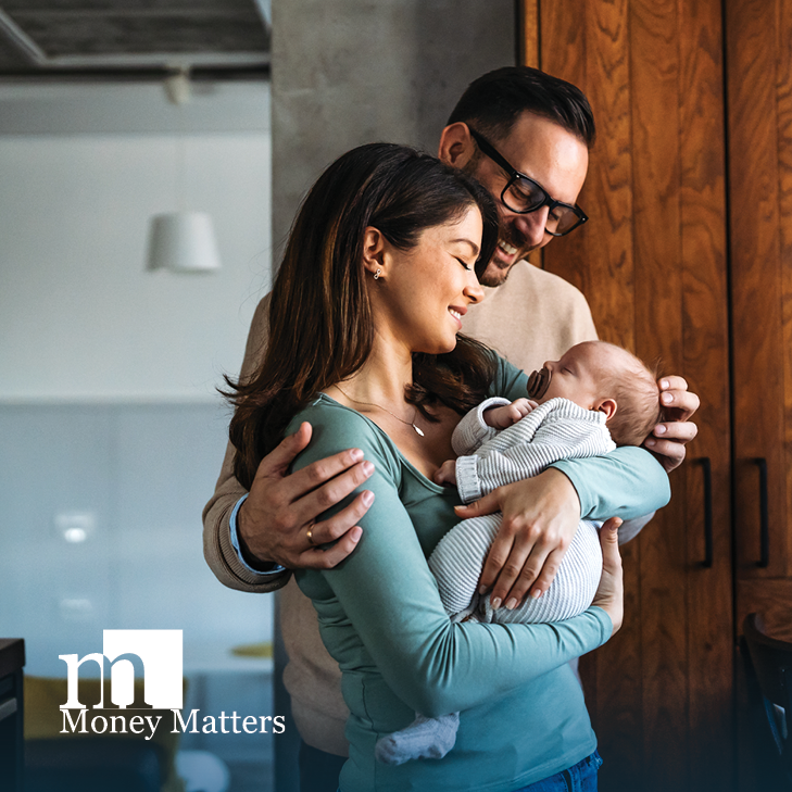 A man and woman stand with a baby.